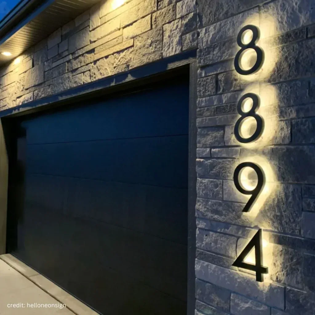 Backlit house numbers on a stone wall