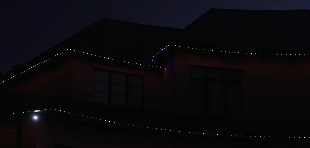 Permanent roofline lights outlining the upper roof edges of a brick home at night