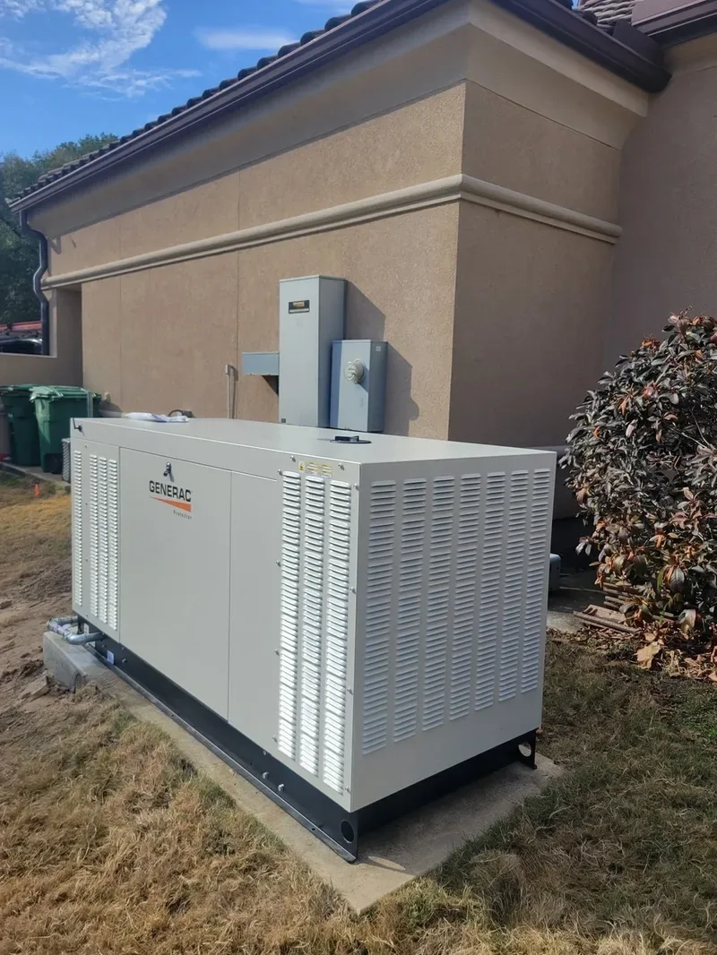Large Generac liquid-cooled generator on a pad beside a stucco building
