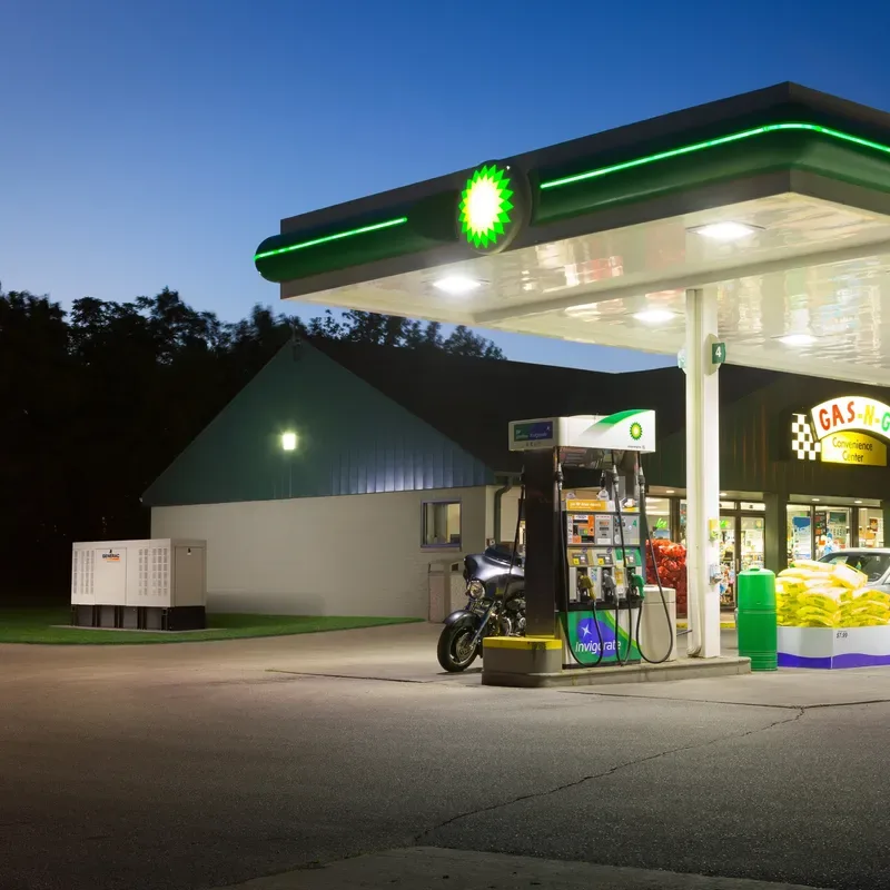 Generac commercial generator next to a lit gas station at night