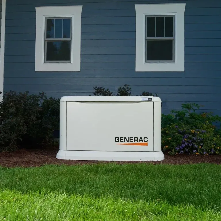 Generac standby generator in flower beds beside a blue house